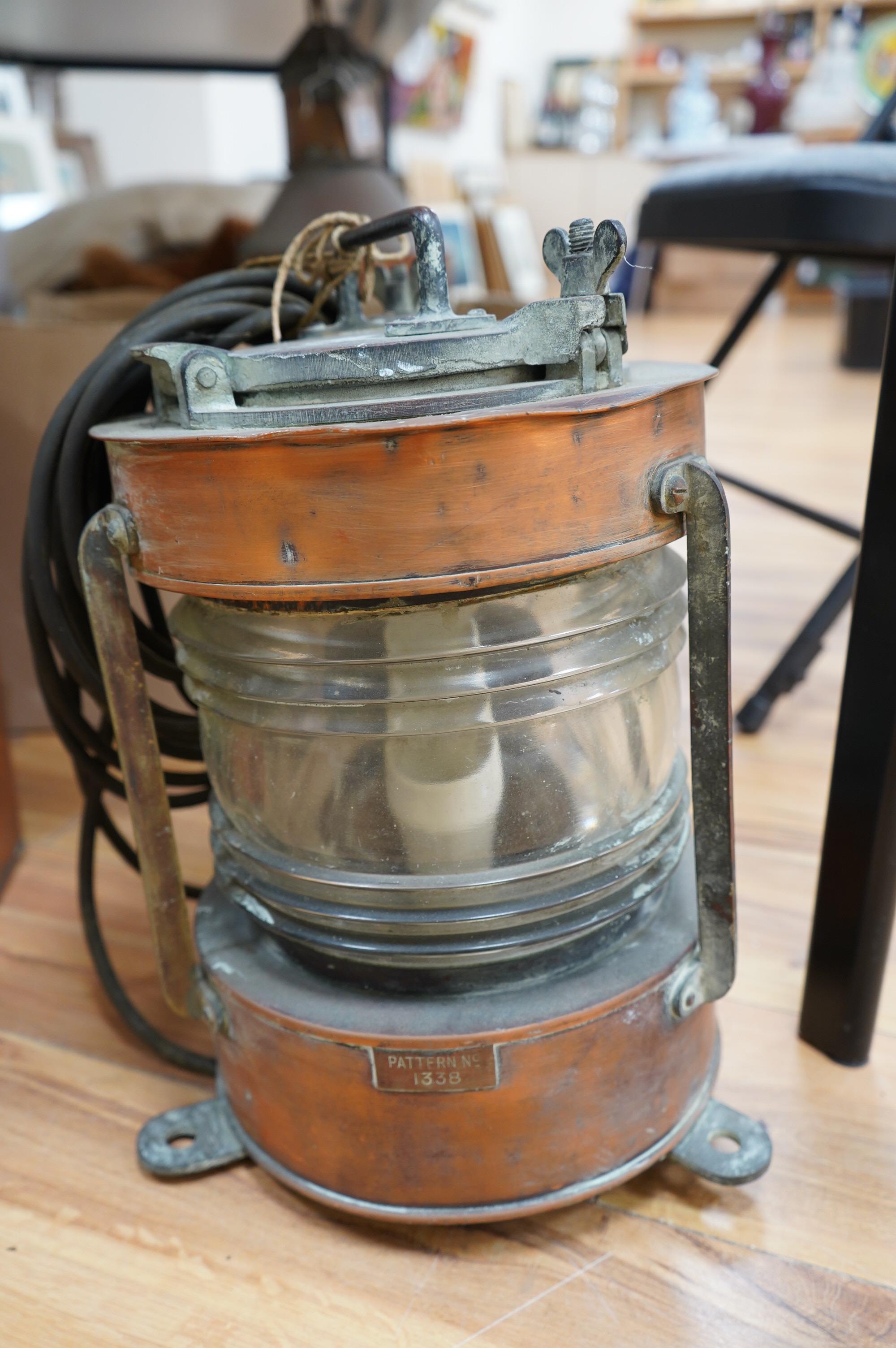 An early 20th century ship’s copper mast head lamp, and another copper ship’s lamp, largest 69cm high. Condition - fair